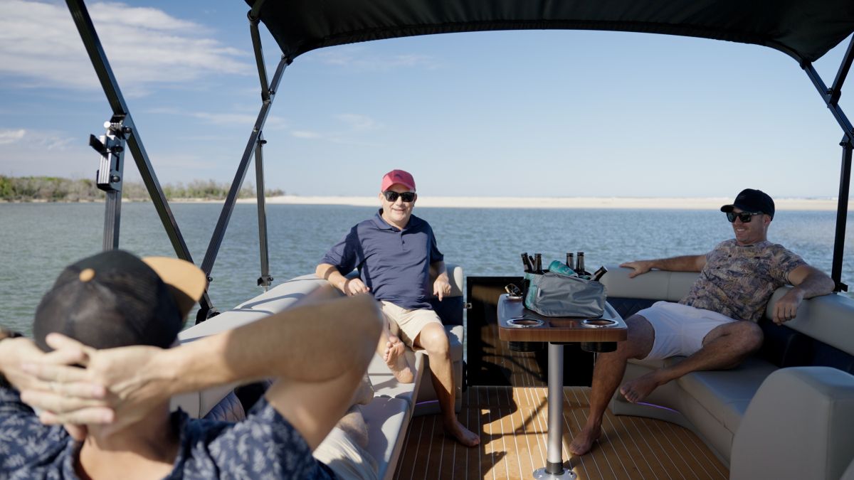 The men relaxing on a triple tube pontoon boat, best build for rivers and lakes